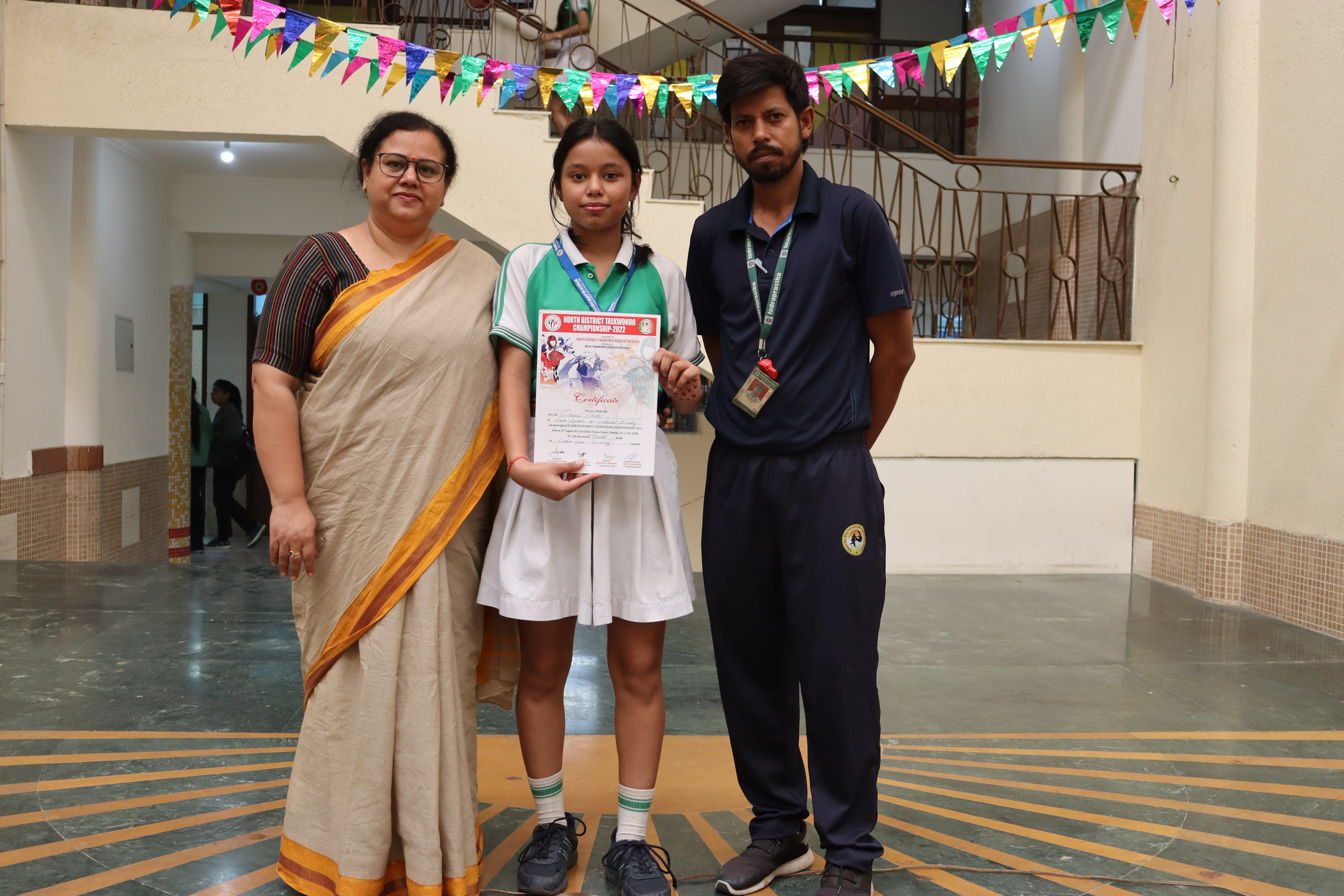 A young participant in Taekwondo championship with teachers.
